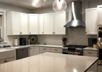 A Large, Clean, And Well-Lit Kitchen With White Cabinets And A White Countertop