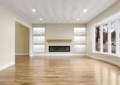 A Spacious, Well-Lit Living Room With Wooden Floors And A Fireplace